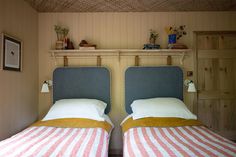 two twin beds in a room with wood paneling