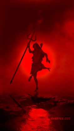 the silhouette of a man holding a spear in front of a red sky