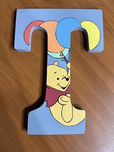 the letter t is painted with winnie the pooh and balloons