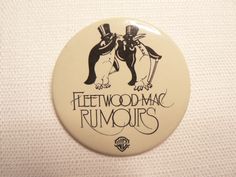 a button with the words fleetwood magic rumours on it, and two penguins in top hats