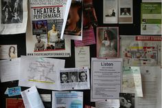 the wall is covered with posters and papers, including one that has been pinned to it