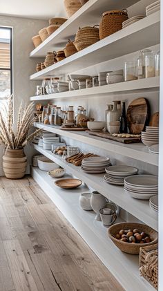 the shelves are filled with dishes and bowls, baskets on each shelf to hold food