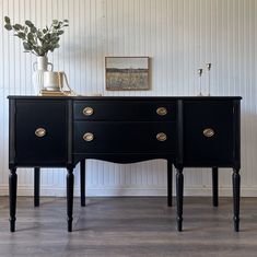 two black dressers with gold handles and knobs on each side, against a white wall