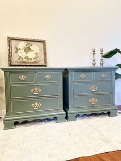 two blue dressers sitting on top of a white rug next to a flower vase