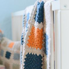 a crocheted blanket hanging on the side of a white radiator next to a bed