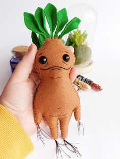 White background. A woman's hand holds a felt mandrake-shaped mascot from the Harry Potter books. Harry Potter Baby Sewing, Harry Potter Felt Crafts, Felt Mandrake, Harry Potter Felt Pattern, Harry Potter Felt Ornaments, Harry Potter Diy Gifts, Felt Harry Potter, Mandrake Harry Potter