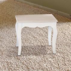 a small white table sitting on top of a carpeted floor