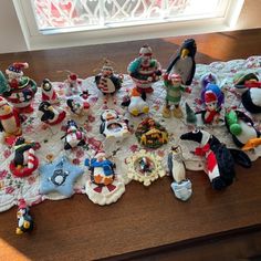 a group of christmas ornaments sitting on top of a wooden table next to a window