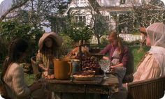 four women sitting around a table with food on it