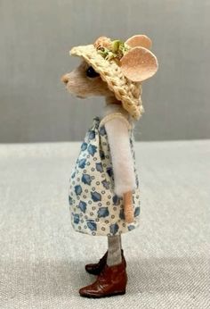 a small mouse wearing a dress and hat