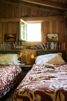 two beds in a room with bookshelves and lamps on the nightstands next to each other