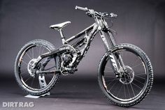 the bike is on display in front of a black background with white lettering that says dirttrac