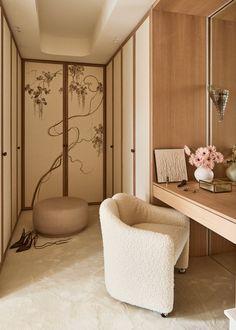 a white chair sitting next to a wooden desk in a room with paintings on the walls