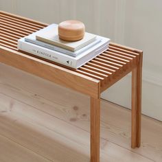 a wooden table topped with books and a small bowl on top of each bookcase