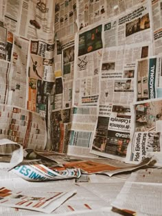 newspapers spread out on top of a bed covered in paper and newspaper clippings