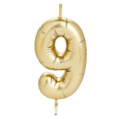 a gold balloon shaped like the number eight on a stick with a single toothpick sticking out of it