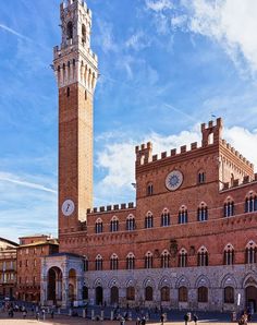 a tall brick building with a clock tower in the middle of it's front