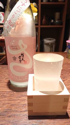 a bottle of sake and a wooden box on a table