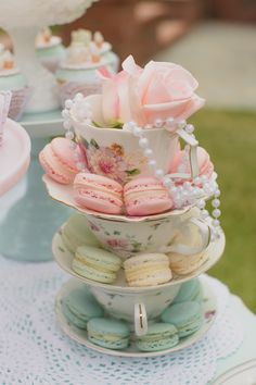 three tiered trays filled with cupcakes and macaroons on top of each other