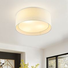 a white ceiling light in a living room next to a table with flowers on it