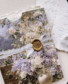 an altered photo with flowers and a wax stamp on it's cover is shown