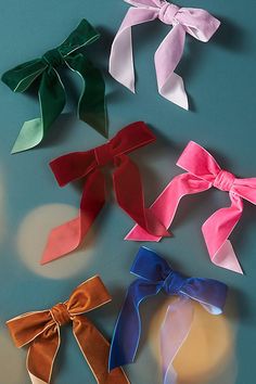 four different colored bows on a blue surface