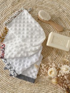 soap bar, comb and flower on woven placemat with natural items for skin care