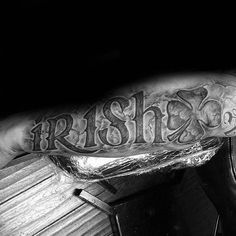 black and white photograph of a man's arm with the word irish on it