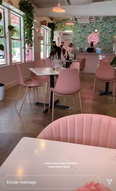 the inside of a restaurant with pink chairs