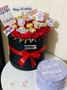 a birthday cake sitting on top of a table next to a hat box with greeting cards