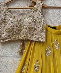 Mustard Yellow Georgette lehenga embellished with floral hand embroidered buttis and a shimmering gold border teamed with a beige gold raw silk blouse intricately hand embroidered with mirror, resham, zardozi, beads and cutwork details. Completed with a mustard yellow soft net dupatta with mirror work highlights and a gold zari border Composition : Lehenga - Georgette, Blouse - Raw Silk, Dupatta - Soft Net All products can be customised for sleeves, length of blouse and neck design Delivery : 2- Gold Palazzo Set With Dori Work For Navratri, Gold Palazzo Set With Dori Work For Diwali, Yellow Palazzo Set For Reception And Navratri, Yellow Palazzo Set With Zari Work For Reception, Navratri Reception Palazzo Set With Gota Work, Yellow Mirror Work Sets For Reception, Yellow Georgette Palazzo Set For Reception, Yellow Sets With Mirror Work For Reception, Georgette Sharara With Gota Work For Reception