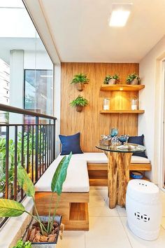 the interior of a small apartment with wood paneling and plants on the balcony area