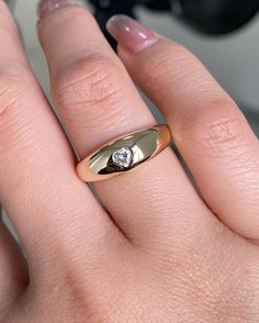 a woman's hand with a diamond ring on top of her finger and the other hand holding an object in front of her