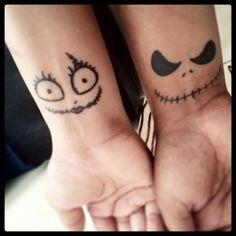 two people with matching tattoos on their wrists holding hands and looking at the camera