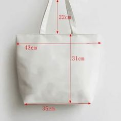 a white tote bag with measurements for the size and width, on a white background