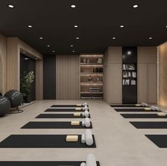 there are many black and white yoga mats on the floor in an empty room with shelves