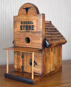 a wooden birdhouse with the words general store on it's roof and window