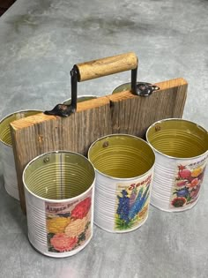 four buckets sitting on top of a table next to a wooden box with handles