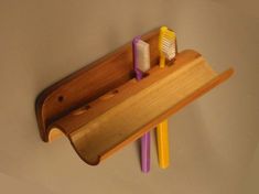 three toothbrushes are placed in a wooden holder