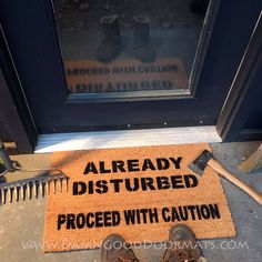 a door mat that says, already disturbed proceed with caution on the front step next to a pair of shoes