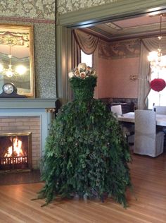 a living room with a fire place and christmas tree in the middle of the room