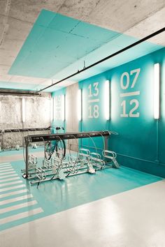 an empty room with blue walls and white flooring is pictured in this image, there are several bicycles parked on the rack