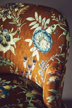 an upholstered chair with floral fabric on it