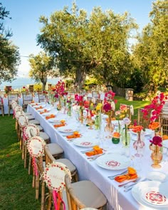 a long table is set up with plates and place settings for an outdoor wedding reception