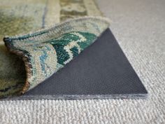 an area rug is laying on the floor next to a piece of carpet that has been rolled over