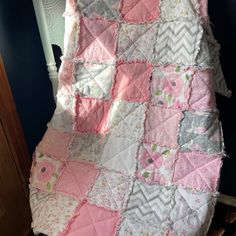 a pink and gray quilt on a bed