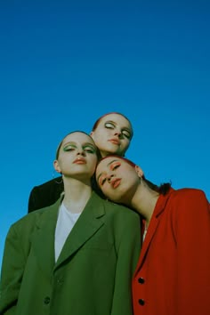 three people with their faces painted to look like they are looking up at the sky