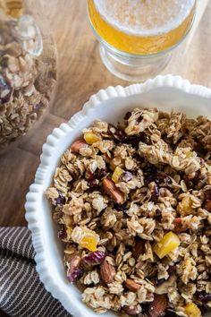 a bowl filled with granola next to a glass of beer