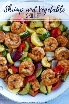 shrimp, zucchini and peppers in a white bowl on a blue tablecloth