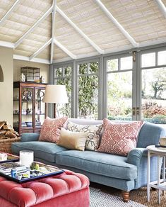 a living room filled with furniture and lots of windows